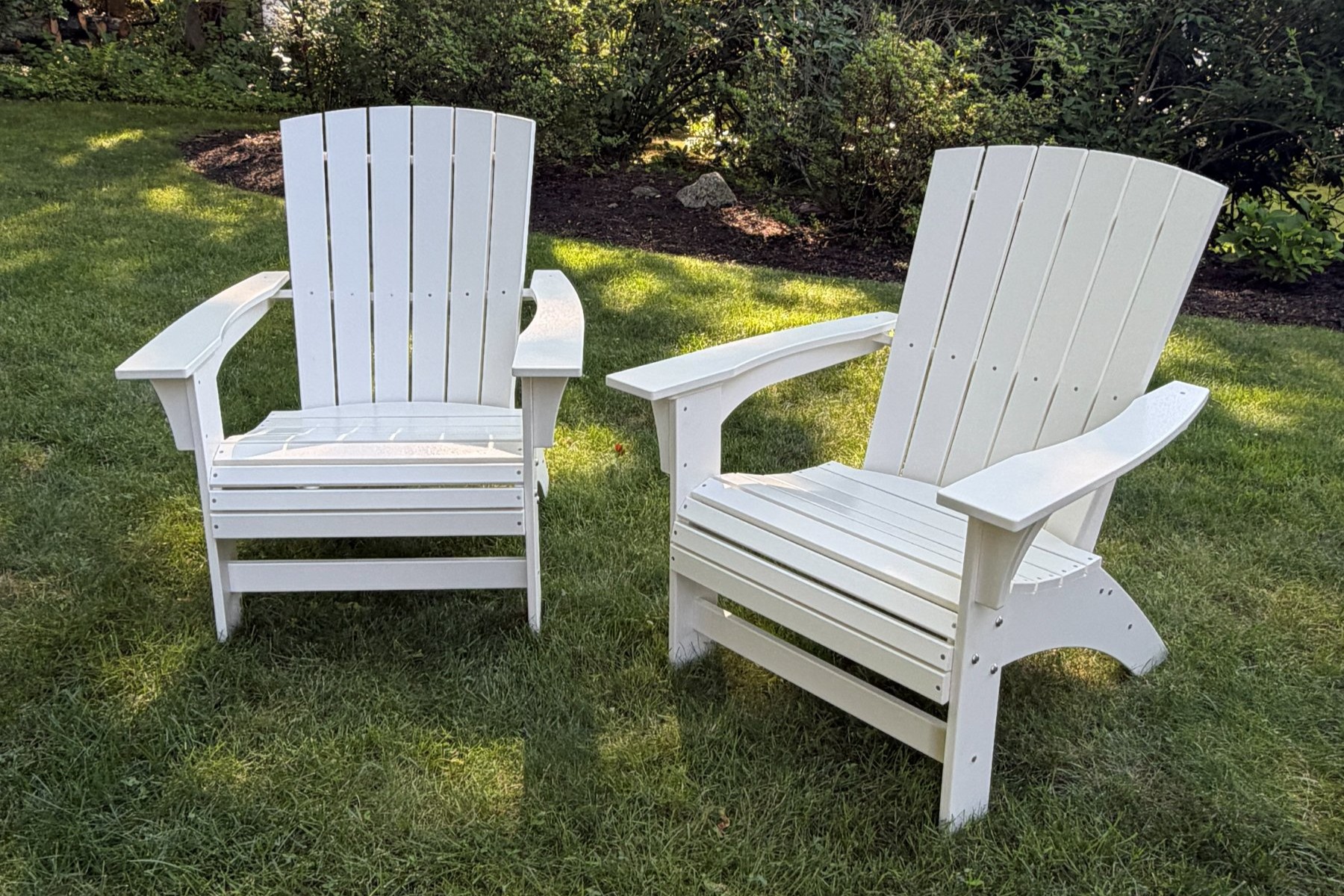Two Coastal Adirondack chairs on a lawn, three-quarter view