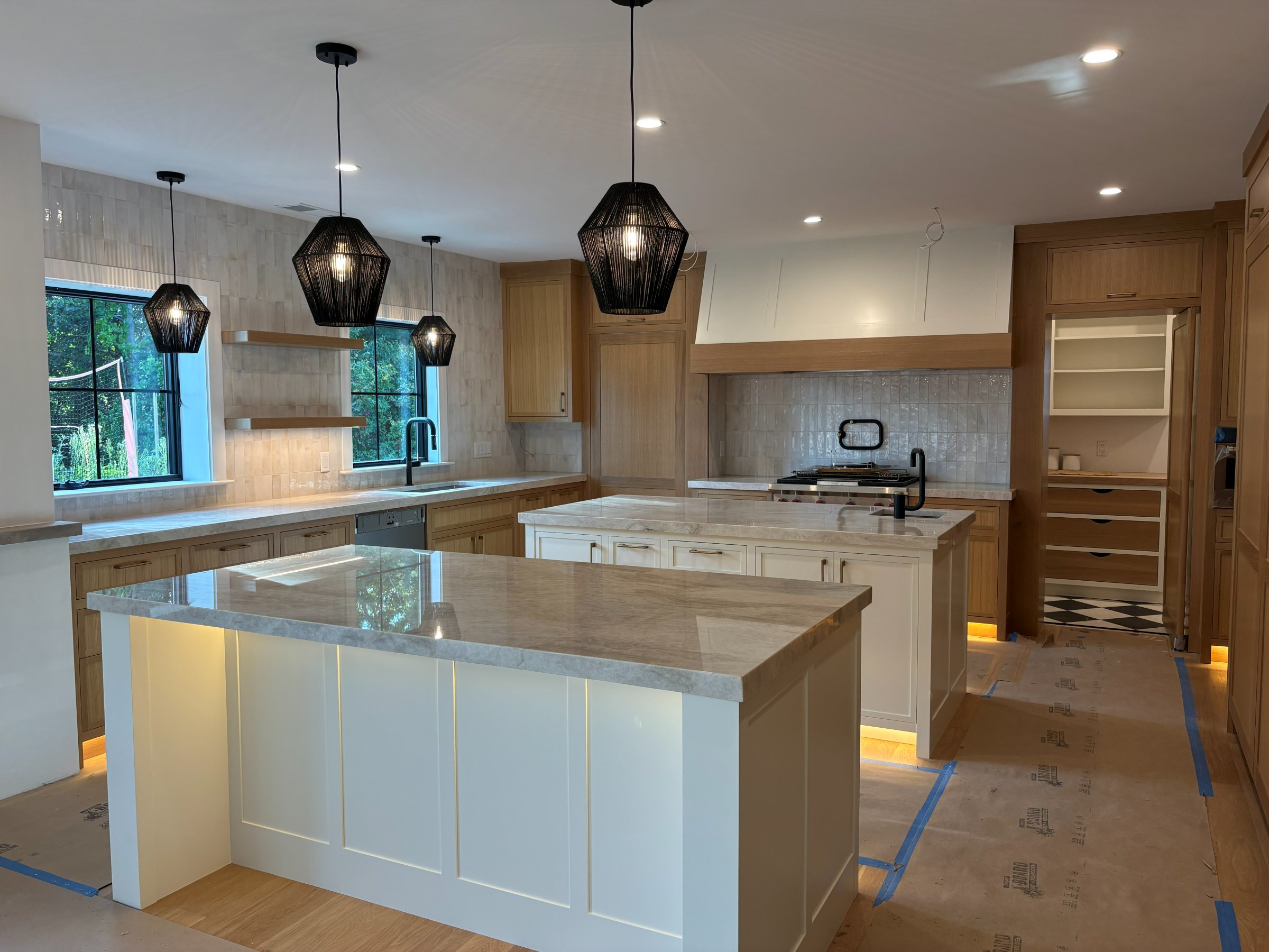 Kitchen with dark pendant lighting and marble countertops