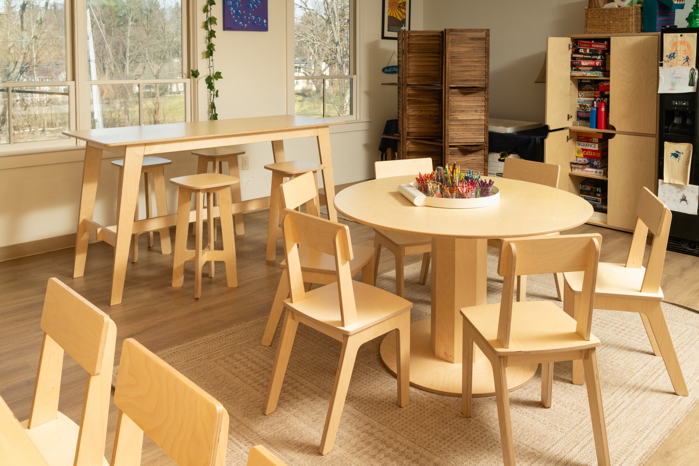 School classroom furniture, including a round activity table and storage shelving